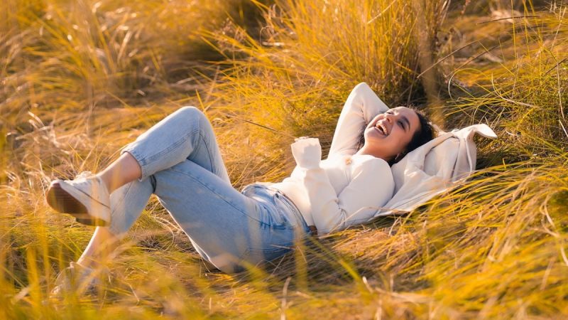 A woman laying in a field of tall grass